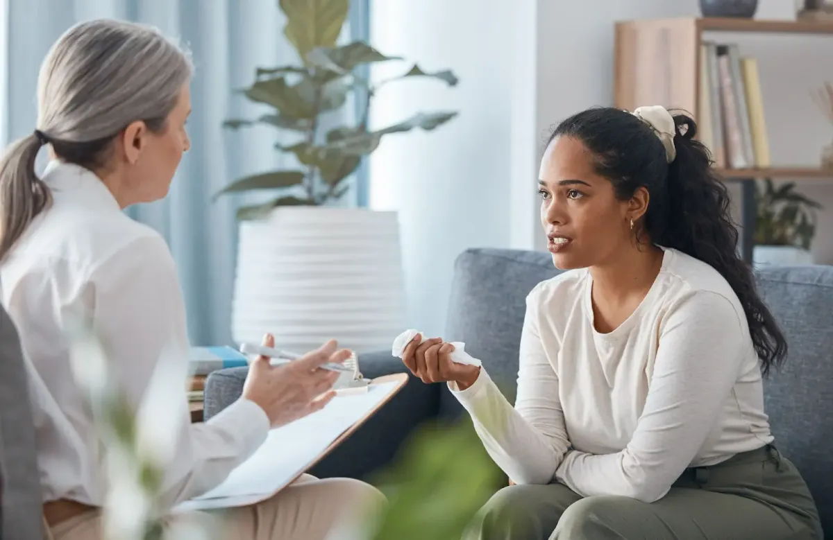 Woman talking with a clinician who is taking notes on a clipboard